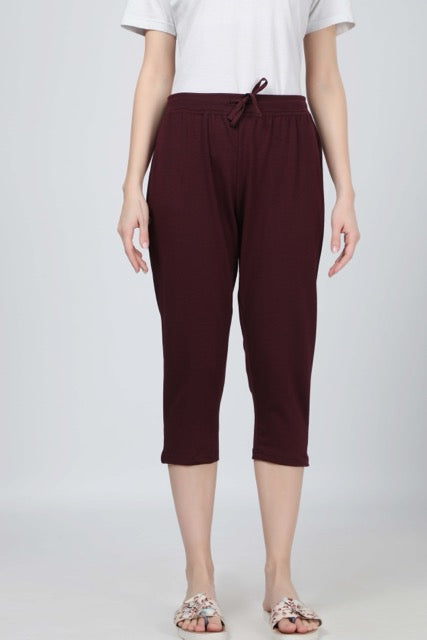 Women wearing burgundy 3/4 yoga pants with side pocket and adjustable drawstring waistband